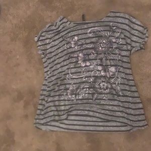 A gray T-shirt with black stripes, a flower design with sequins